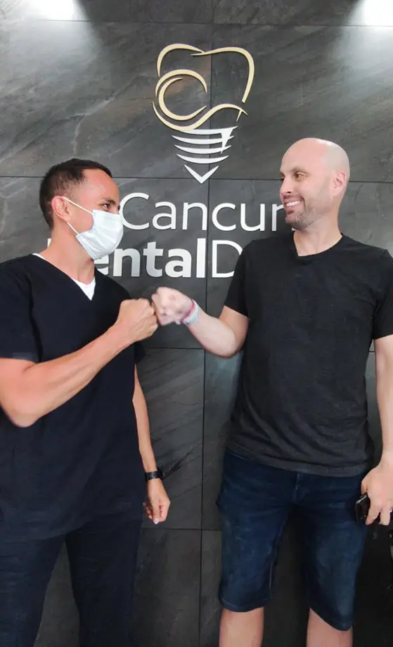 cancun dentist dr. zamora fist bumping with a patient